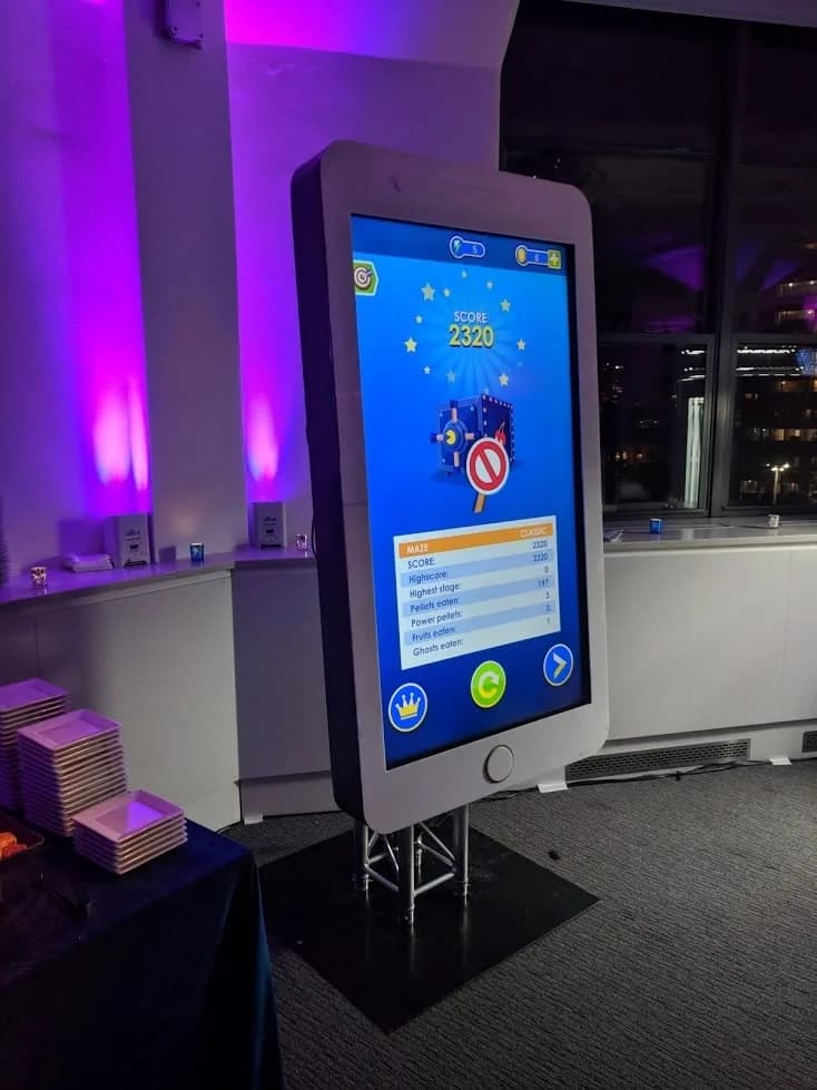 Close-up of the giant touchscreen phone game display showing colorful interactive game interface at an event