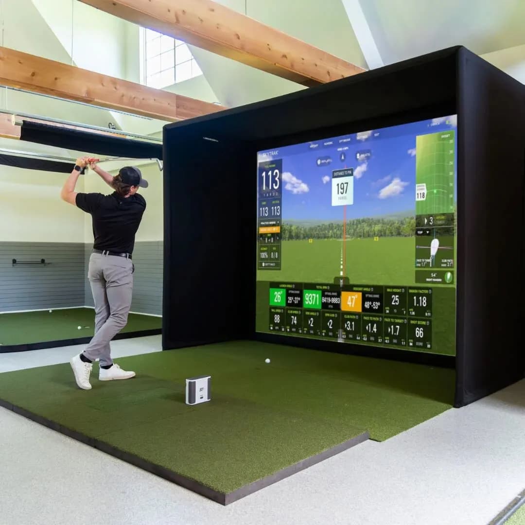 Indoor golf simulator at a corporate team-building event in CT or NYC, showing projector screen with course and real-time swing analysis