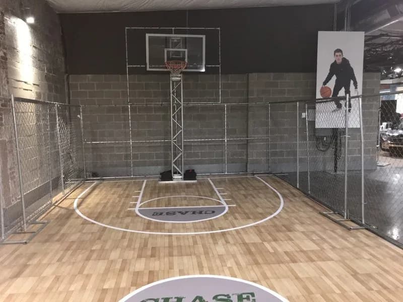 Street-style 3-on-3 basketball cage rental detail at a sports-themed event in Connecticut, chain-link enclosure and lowered rims