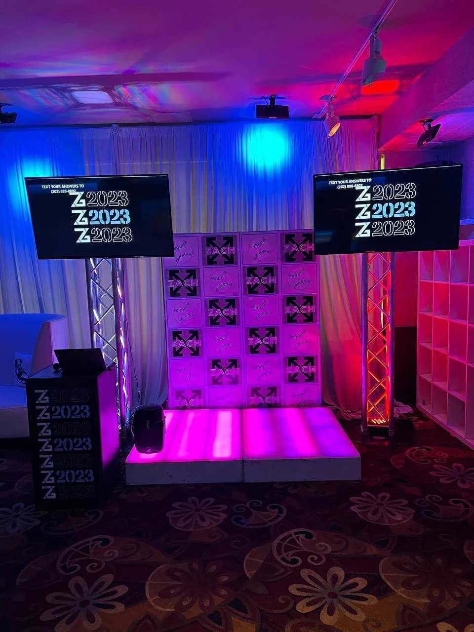 Text-to-win game show display showing live trivia question and contestant answers on screen at a bar mitzvah or sweet 16