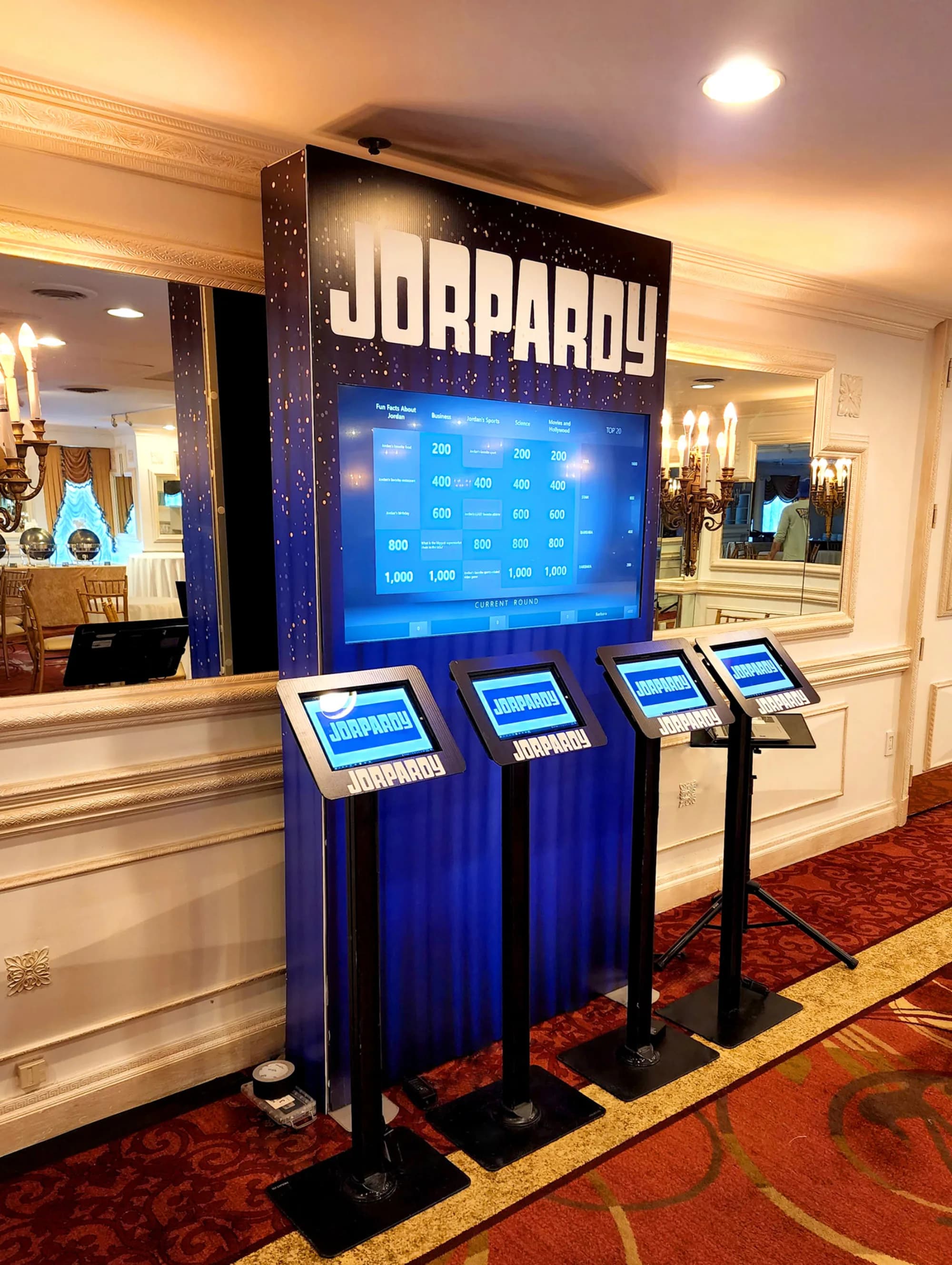 Live trivia game show setup with player podiums and big-screen category board at a mitzvah or corporate gala in Connecticut