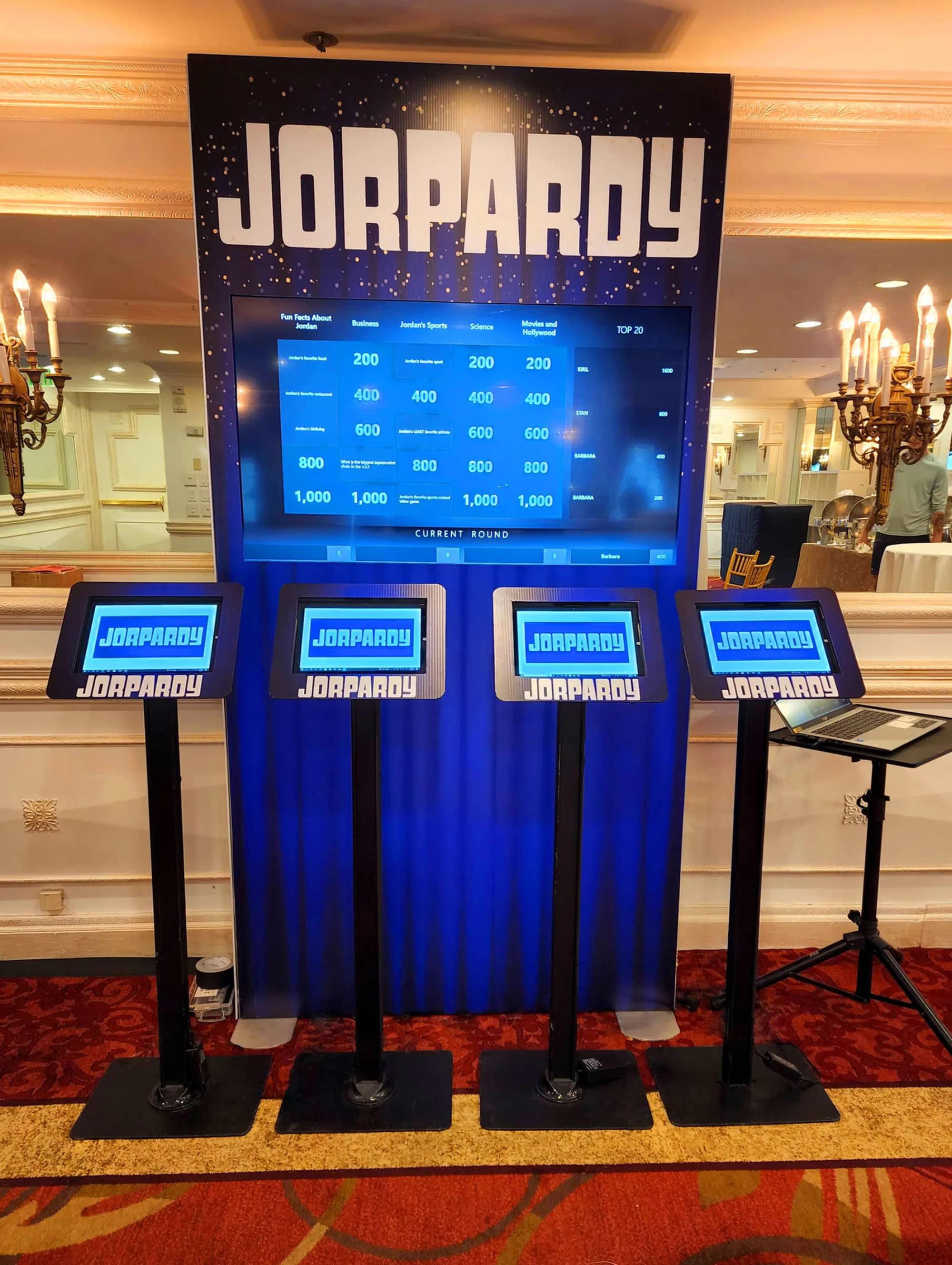 Trivia showdown game show with contestant podiums and buzzer stations at a corporate event or bar mitzvah in NYC