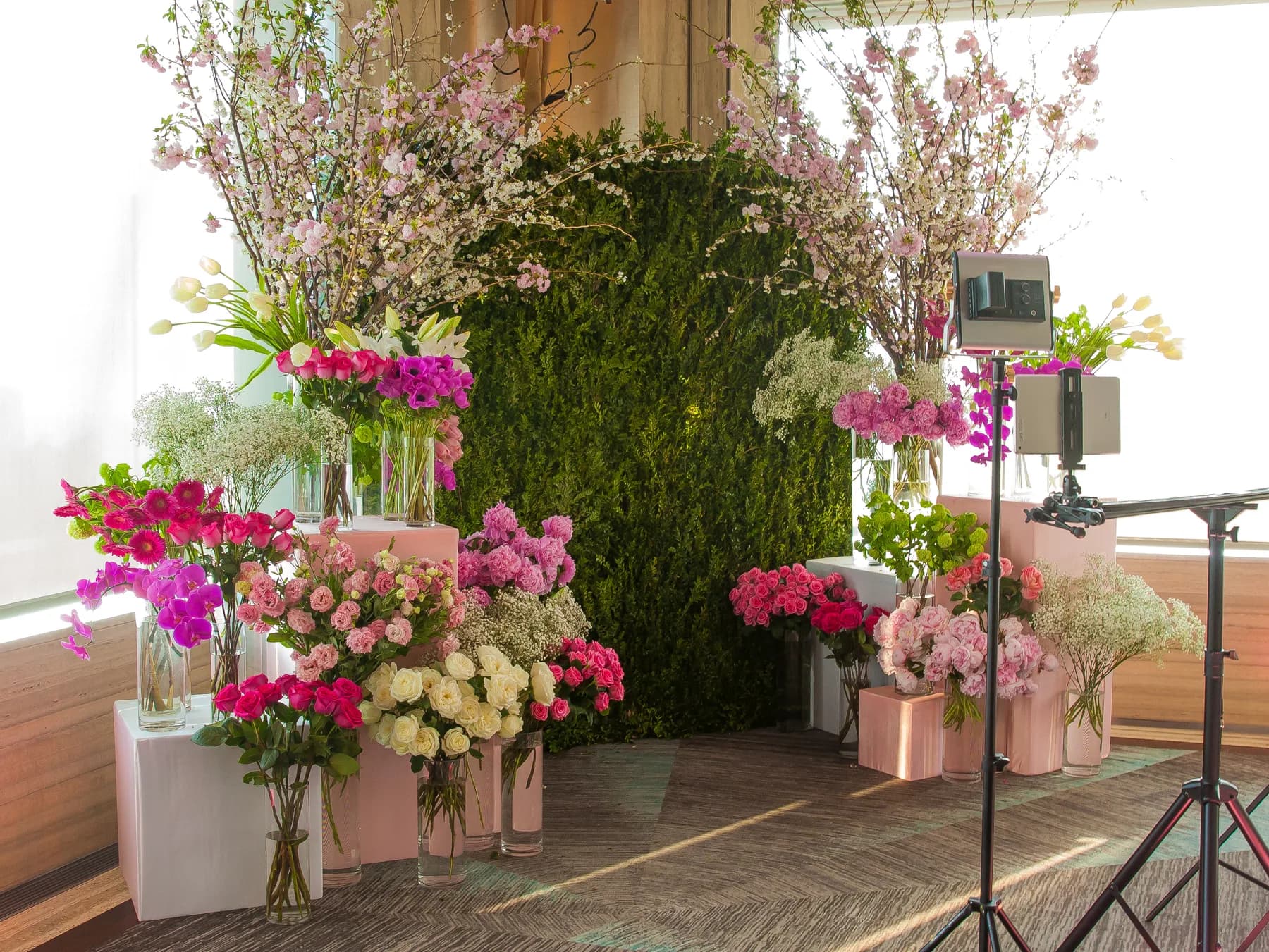 Sliding GIF rail rig positioned in front of a lush floral backdrop at a New York City event