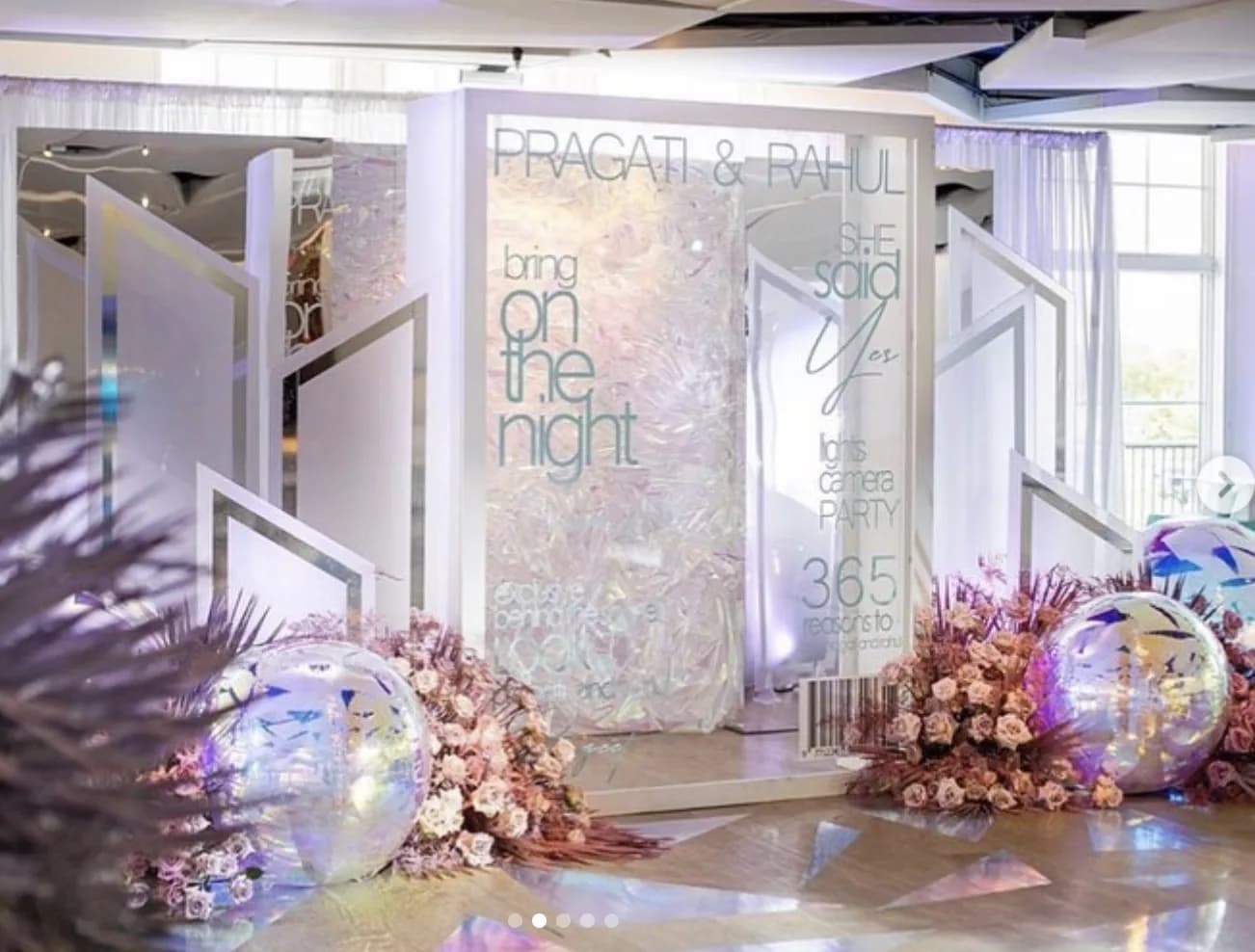 Magazine cover photo booth setup at an event venue with floral backdrop and display screen