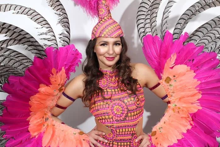 Glamorous performer in feather costume captured at an event by the glam photo booth
