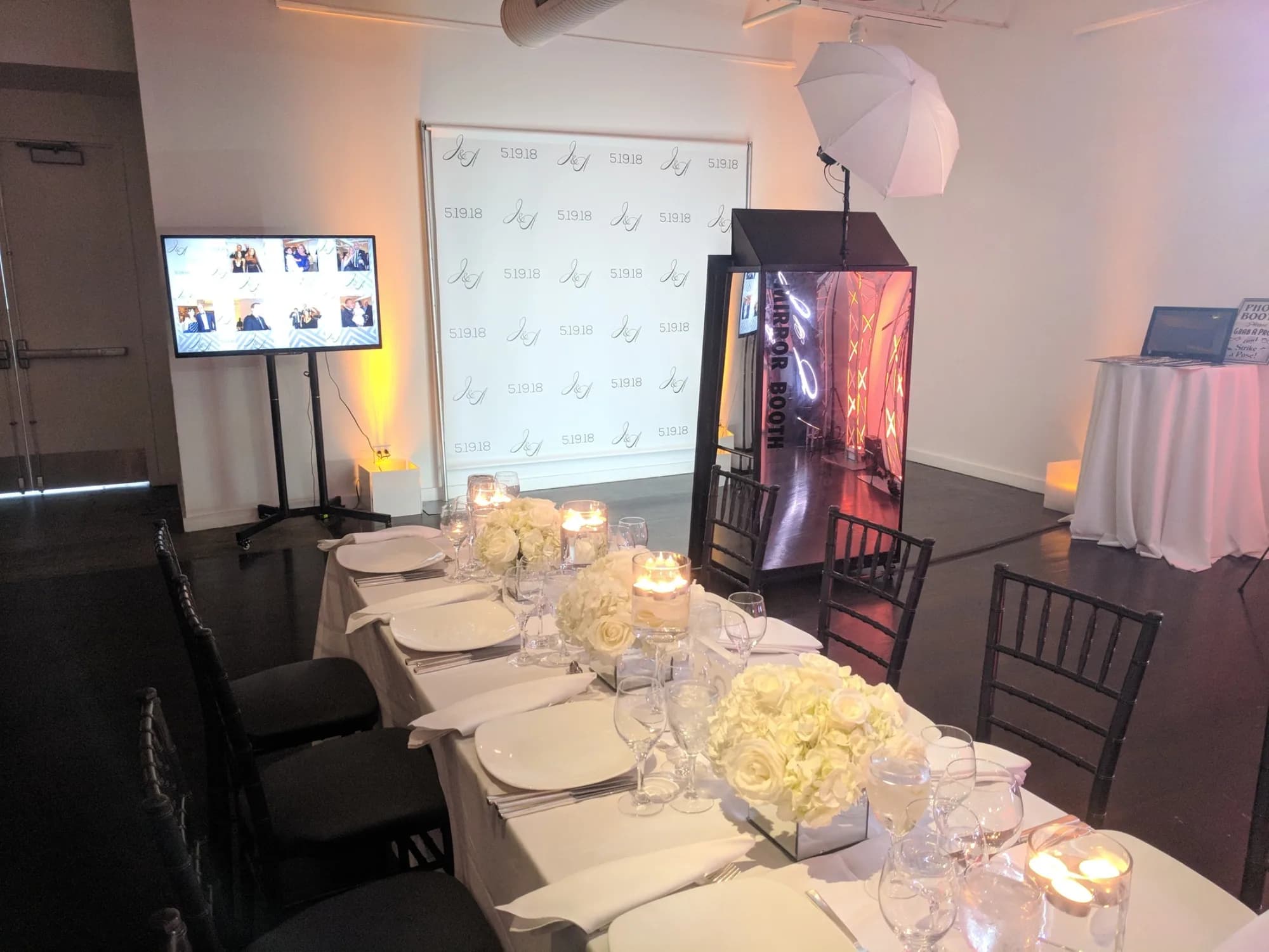 Mirror photo booth beside an elegant candlelit dinner table at a Connecticut event venue