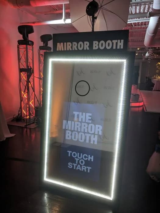 Mirror photo booth welcome screen displaying Touch to Start prompt with LED border lighting