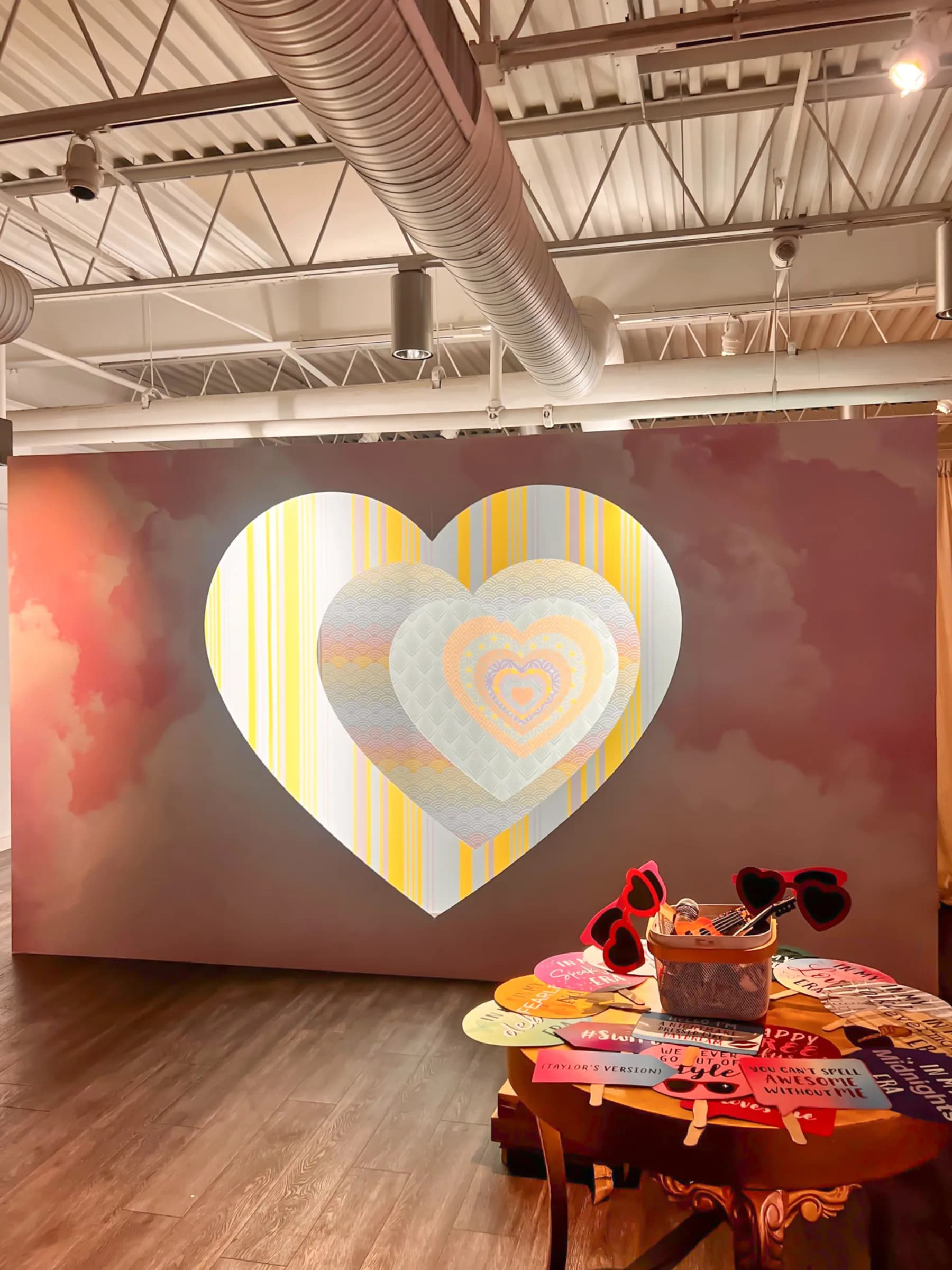 Endless hearts wall installation in a large event venue with heart-shaped prop table in the foreground