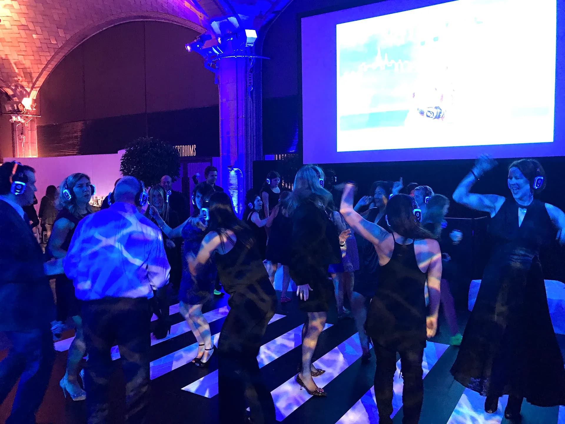 Guests dancing in glowing wireless headphones at a silent disco produced by Nicholson Events in NYC