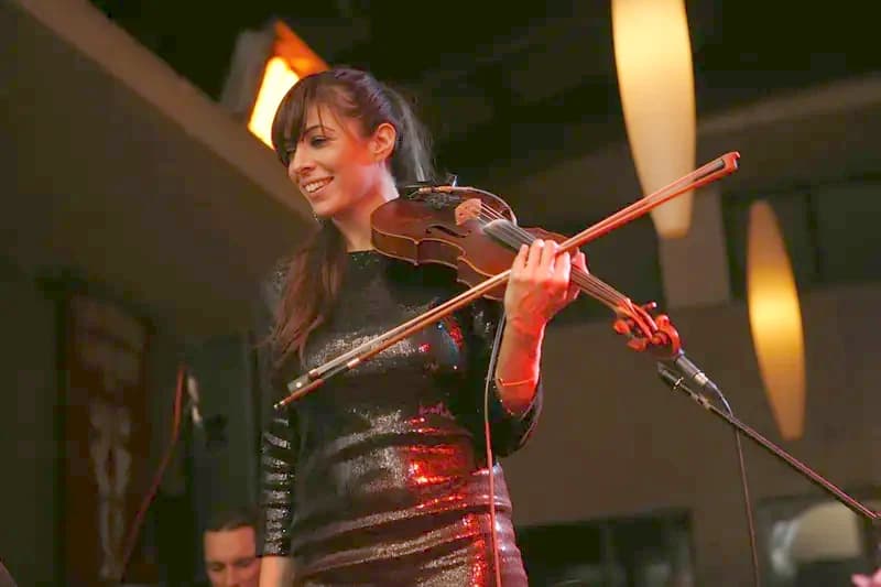 Electric violinist performing at a luxury event with dramatic lighting