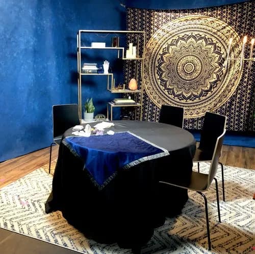 Tarot reading table set with crystals and candles against a gold mandala backdrop