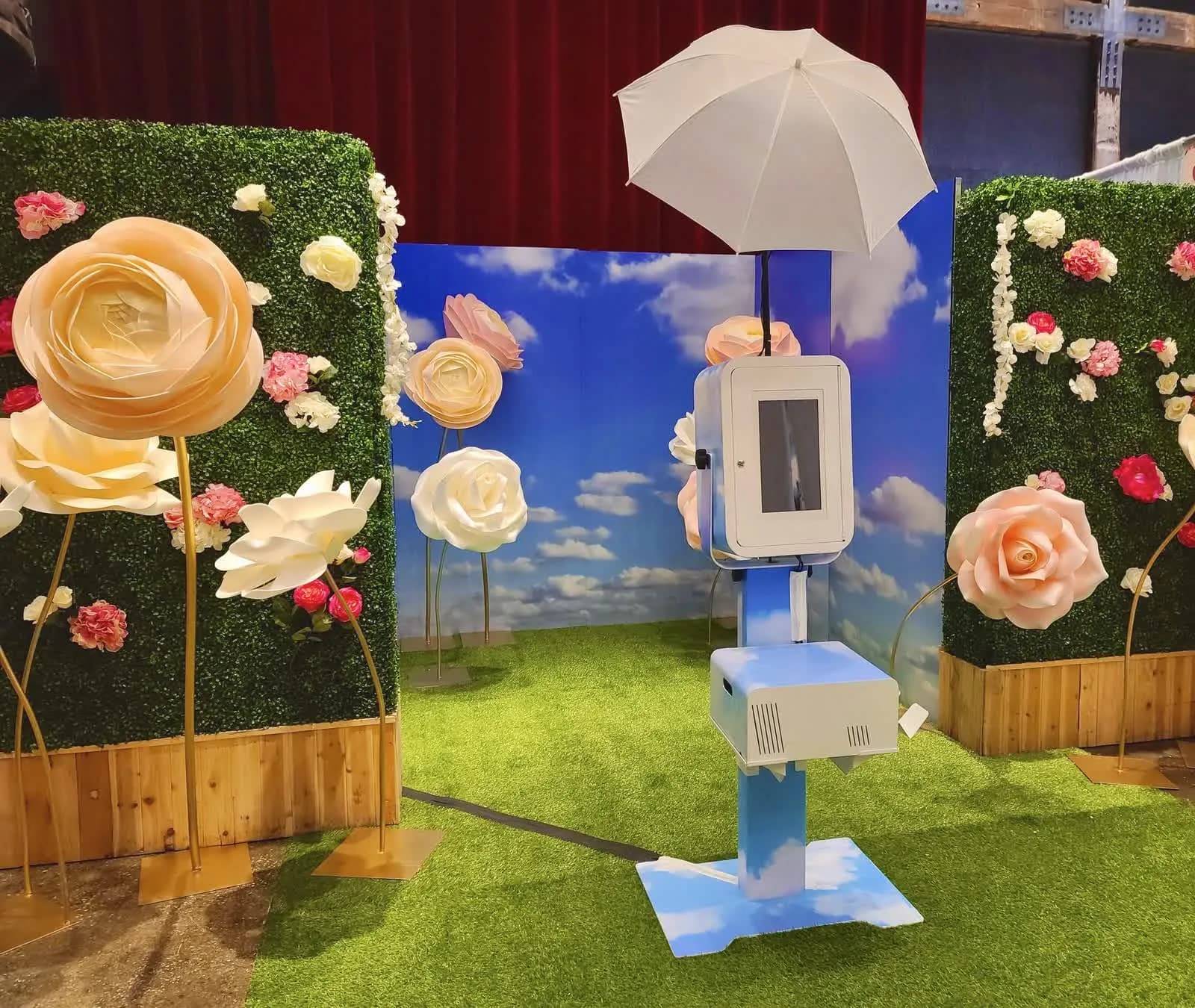 Walk-in flower garden photo experience with oversized paper roses and a sky backdrop at an event