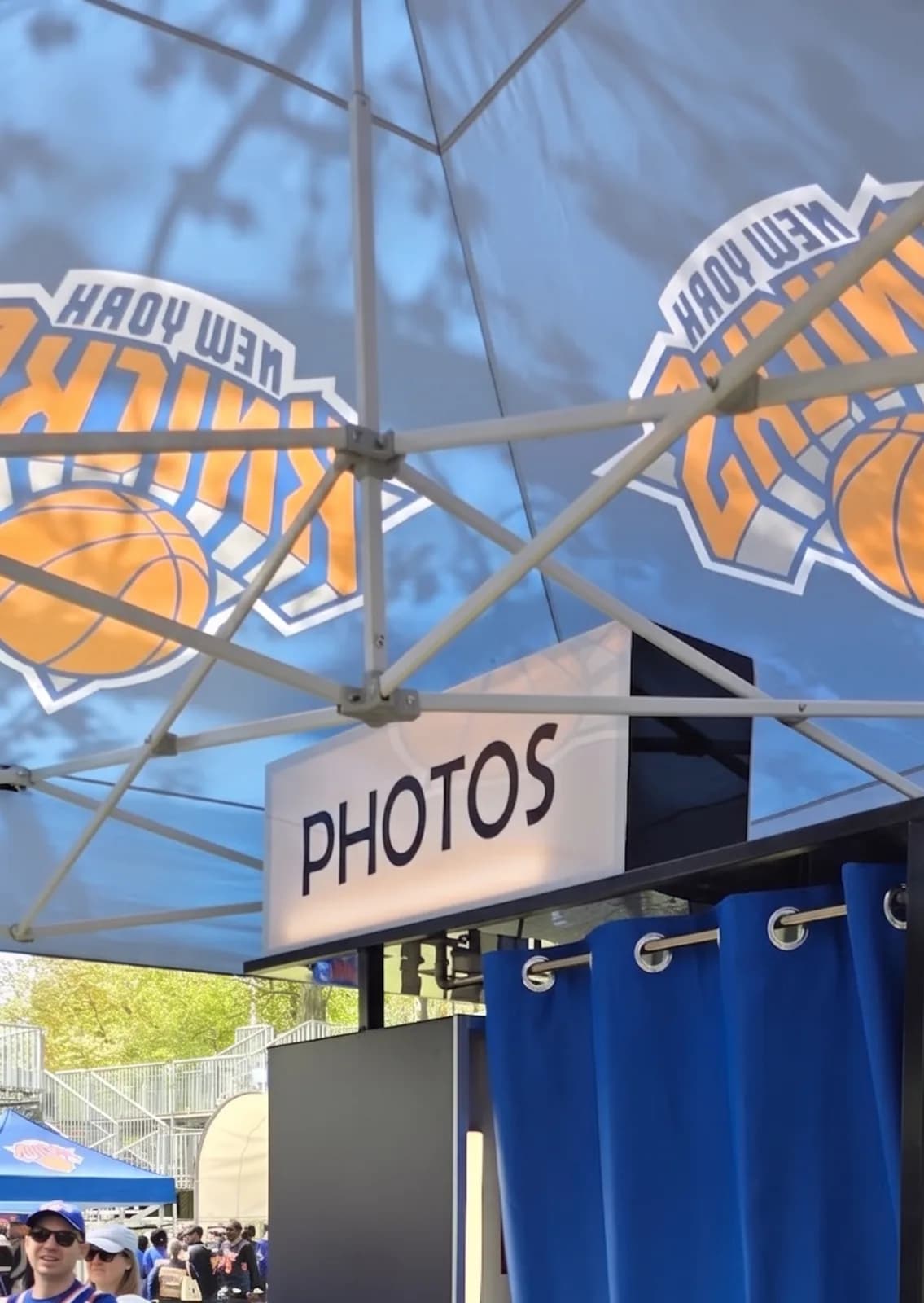 Vintage curtain-style sports photo booth with a basketball team canopy and a Photos sign at an outdoor event