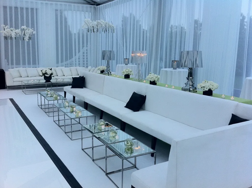 White tented lounge with white sofas and a white dance floor at a Hamptons summer party by Nicholson Events
